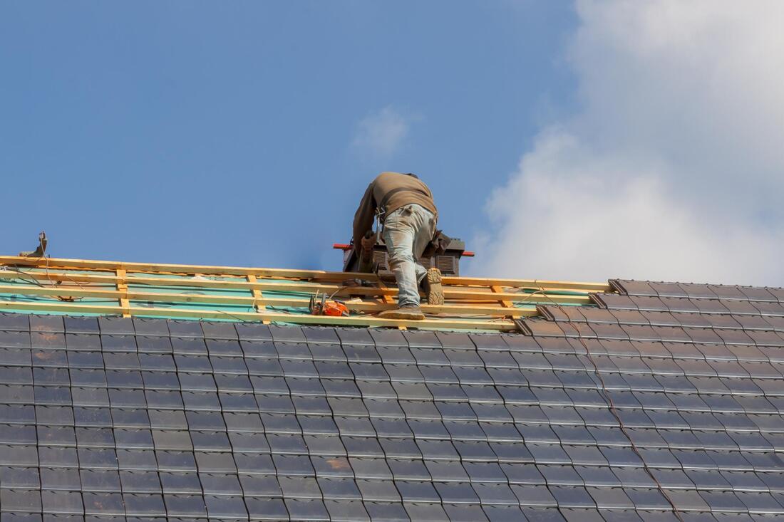 professional roofer working on fiberglass shingles